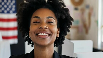 Smiling woman with curly hair in an office setting near an American flag during daytime - Powered by Adobe