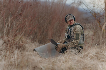 Soldier using laptop in the wilderness for tactical communication