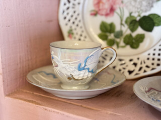 vintage floral teacup set on rustic wooden shelf