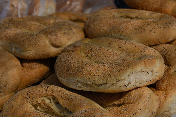 Freshly baked bagels piled high at a bustling street market in the early morning sun