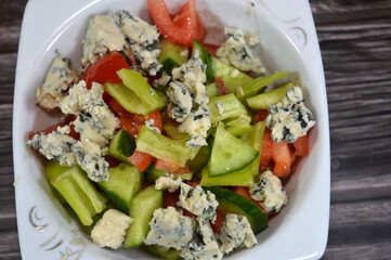 pieces of blue cheese, Blue cheese salad with slices of green chili peppers, tomatoes and cucumbers, cheese with edible molds, which create blue-green spots or veins through the cheese