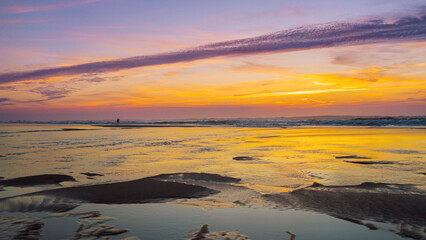 Vibrant Sunset Over Ocean Shore With Gentle Waves and Scenic Silhouettes