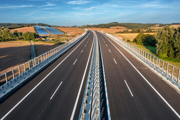 An empty highway bridge  stretches across the Czech landscape, seen from above. Highway D6 from Prague to Karlovy Vary and Cheb.