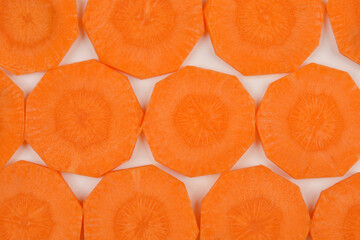 A top-down, flat-lay shot of numerous carrot slices arranged in a grid pattern, showcasing their vibrant orange color and distinct shape