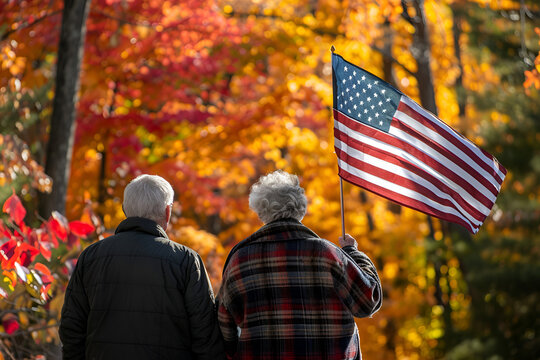 Elderly couple holding an American flag during an autumn walk - Powered by Adobe