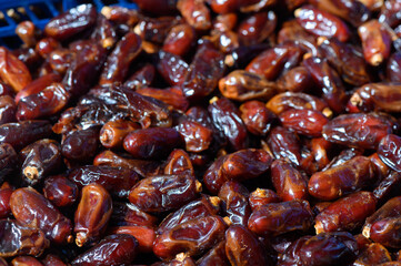 Dried dates piled together in a vibrant marketplace during the afternoon sun