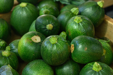Fresh green zucchinis arranged beautifully at a local farmers market in autumn
