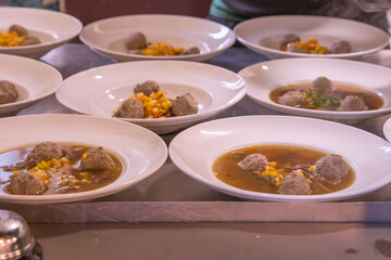 Dumpling soup being prepared for serving at a restaurant on a wedding table