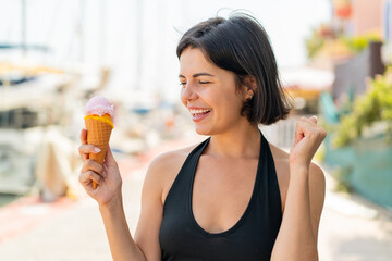 Young pretty Bulgarian woman with a cornet ice cream at outdoors celebrating a victory