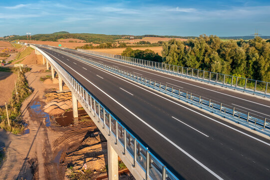 An empty highway bridge  stretches across the Czech landscape, seen from above. Highway D6 from Prague to Karlovy Vary and Cheb.