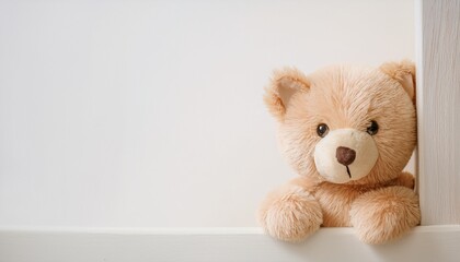 Adorable plush teddy bear toy peeking shyly around the corner on a white background with soft pastel tones