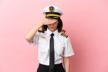 Airplane middle aged pilot woman isolated on pink background covering eyes by hands. Do not want to see something