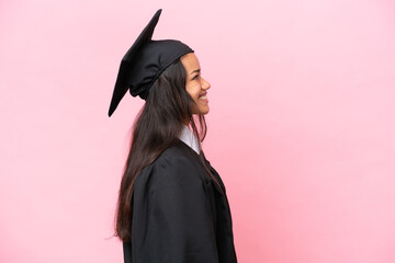 Young university Colombian woman graduate isolated on pink background in lateral position