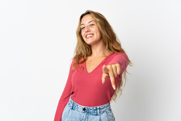 Young blonde woman isolated on blue background pointing front with happy expression