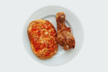 Mini pizza and fried chicken thigh on a white plate. White background.