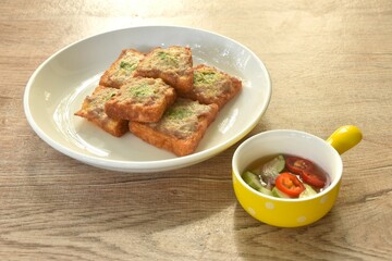 Thai crispy fried pork toast on plate eat couple with pickled vegetable sauce