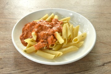 baking penne pasta topping slice salmon in sweet and sour sauce on plate    