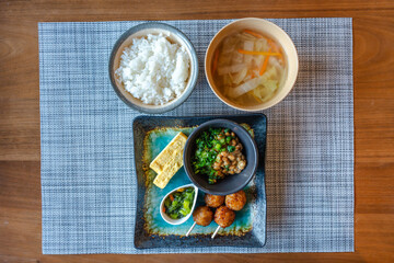 納豆と焼き鳥の和朝食が並ぶ食卓
