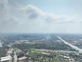 The River's Embrace: An Aerial Glimpse of little town Urban Heart. This drone photograph captures a wide aerial view of Nakhon Pathom, Thailand, with a focus on the river that flows through town