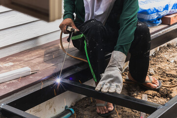 Worker welder performs Arc welding process of metal structures.