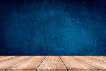 Dark blue background, with empty wooden table, dark wall background. Empty workplace in front of abstract package.