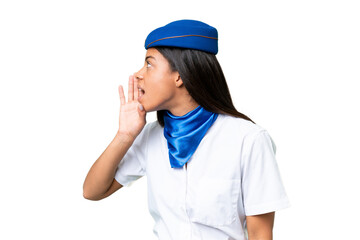 Airplane stewardess African american woman over isolated background shouting with mouth wide open to the lateral