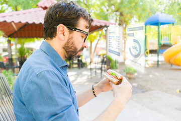 Man sporting AR glasses scanning sandwich nutritional data through cutting-edge digital interface