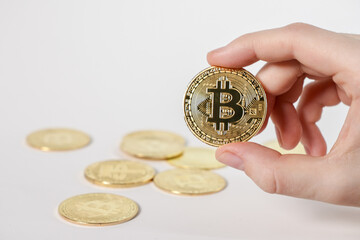 shiny bitcoin coin with multiple golden bitcoins on white background, concept of cryptocurrency...