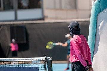 Tennis player, playing on a hard court playing a tennis match in summer