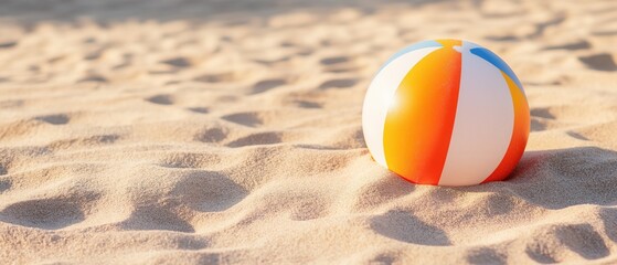Obraz premium Beach ball lying on the sand. the ball is round and has a striped pattern of orange, yellow, and white colors. the stripes are evenly spaced and run horizontally across the ball.