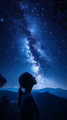 Fototapeta premium Cosmic Contemplation: A silhouetted person gazes in awe at the breathtaking expanse of the Milky Way, evoking a sense of wonder and the vastness of the universe.