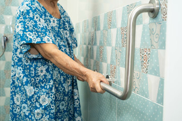 Asian elderly old woman patient use toilet support rail in bathroom, handrail safety grab bar,...