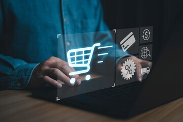 Businessman using lap top computer with virtual trolley shopping cart to order for online shopping...