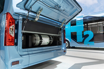A hydrogen fuel cell buses. One bus with an open hood and a hydrogen cylinder inside