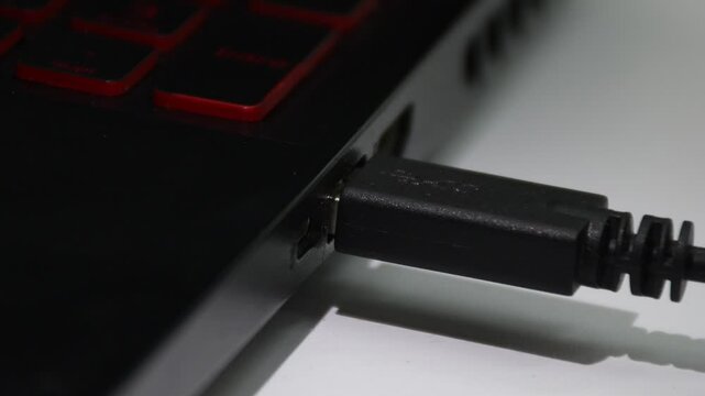 Connecting a USB cable to a computer, hand plugging device into USB port. High quality 4k footage