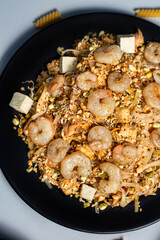 Asian Stir Fried Shrimp and Noodles. Sesame Noodles with Shrimp in black plate with tofu. Asian, authentic food concept.