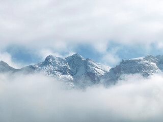 Scenic view of snowcapped Zugspitze mountain range  visible through a gap in the clouds
