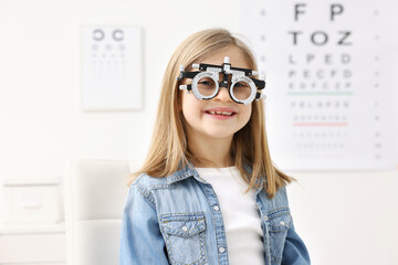 Vision testing. Little girl with trial frame at ophthalmologist office