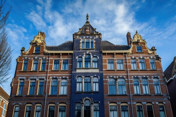 Fototapeta premium Historic Dutch Orphanage Building in Groningen: A Glimpse of Ancient Architecture Against a Blue Sky