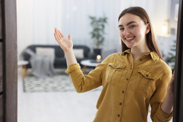 Happy woman welcoming friend to her house