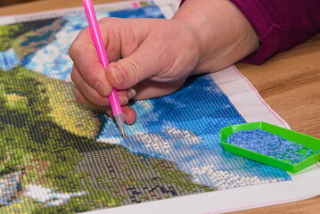 Person beim Gestalten eines Bildes mit Diamond painting