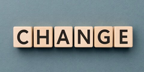 Wooden blocks spelling the word "CHANGE" on a blue background.