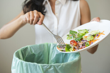 Compost from leftover food asian young housekeeper woman, female hand holding salad bowl use fork...