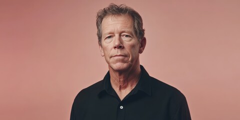 Fototapeta premium Portrait of a Mature Man Against a Soft Pink Background, Exuding Confidence and Wisdom