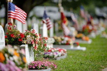 A row of flags and flowers on a cemetery grave