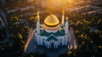 An aerial view showcases a beautiful gold domed mosque at sunset
