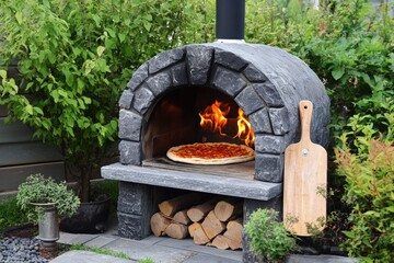 Wood fired pizza oven with wooden paddle and fresh pizza in garden Generative AI