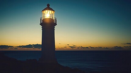 Naklejka premium Illuminated Lighthouse at Sunset Over the Ocean