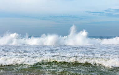 Panorama of natural Indian Ocean with big foamy waves crashing on sandy shore. Sri Lanka. Asia