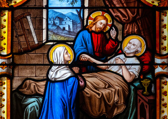 Fototapeta premium Stained glass (19th century) of Death of Saint Joseph surrounded by Mary and Jesus.